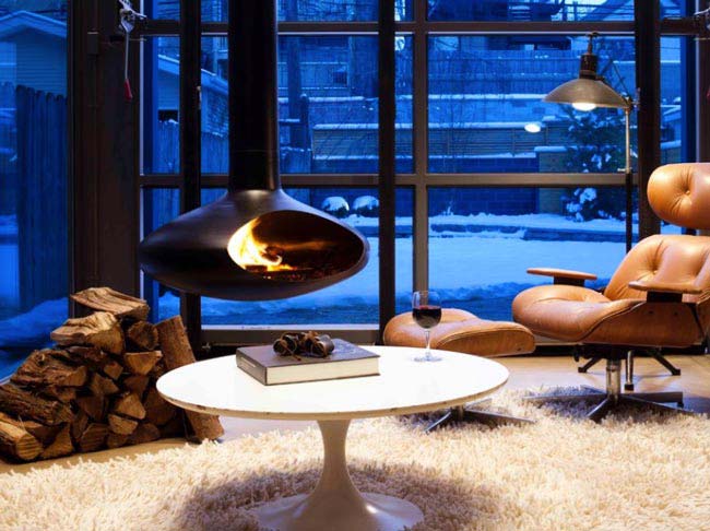 شومینه ای معلق در اتاق شیشه ای با هیزم های آماده سوختن
